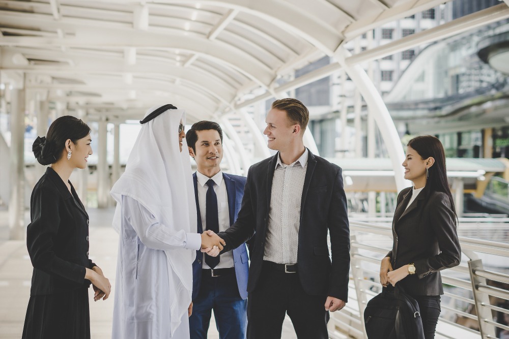 four people talking each other inthat 2 people shaking hands